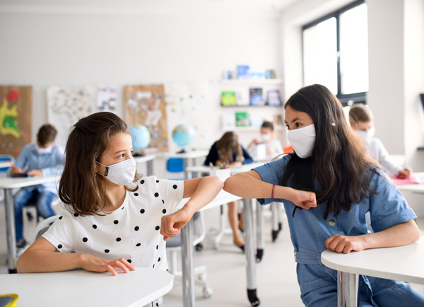 Kids touching elbows to say hello during class