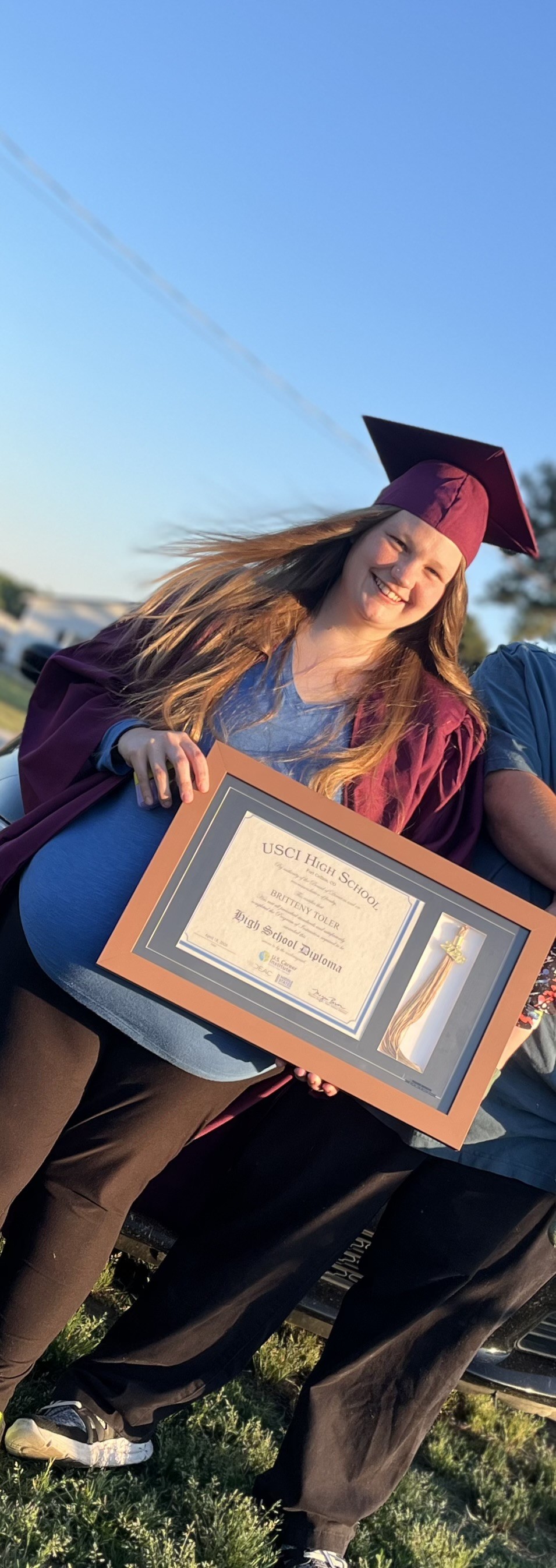 Graduate holding high school diploma